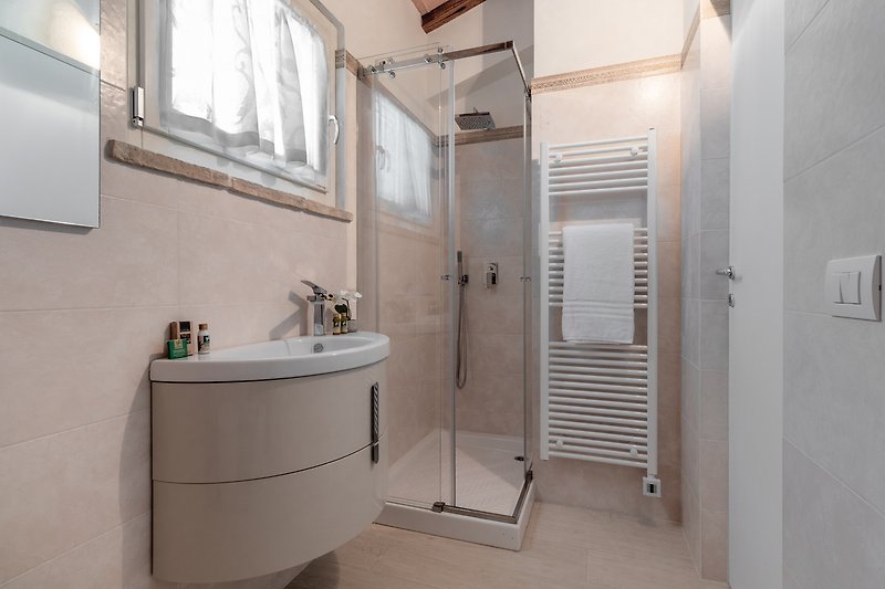 Rent this stylishly designed bathroom with a sleek mirror, sink, and tap.