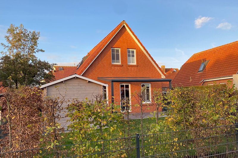 Charmantes Landhaus mit Ziegelmauerwerk und grünem Garten.