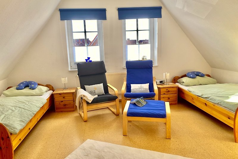 Schlafzimmer mit Baby-Reisebett  Tv  und Sessel