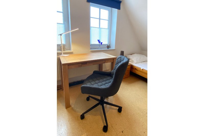 Büroarbeitsplatz mit Holztisch mit verstellbarenm Schreibtischstuhl