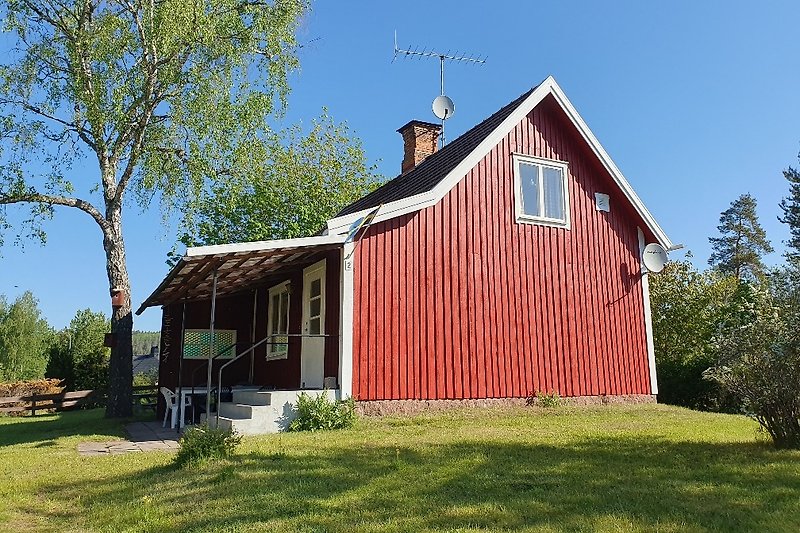 Charmante Ferienhaus mit Holzfassade und grünem Garten.