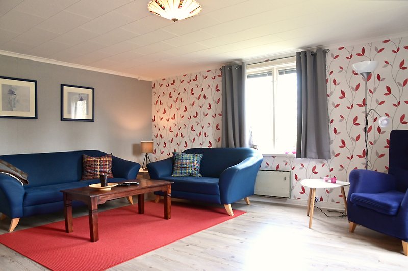 Gemütliches Wohnzimmer mit blauer Einrichtung und Holzboden.