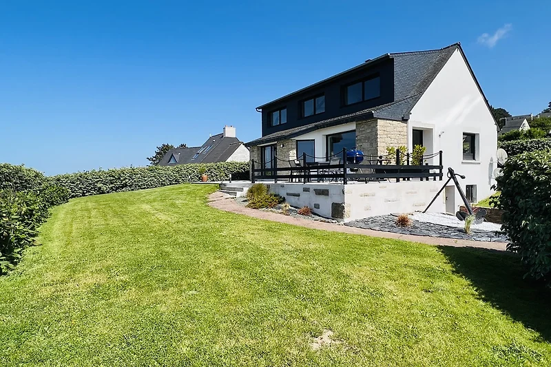Schönes Haus mit grünem Garten und malerischer Landschaft.