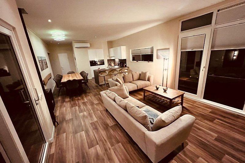 Stilvolles Wohnzimmer mit bequemer Couch, elegantem Tisch und dekorativen Elementen.