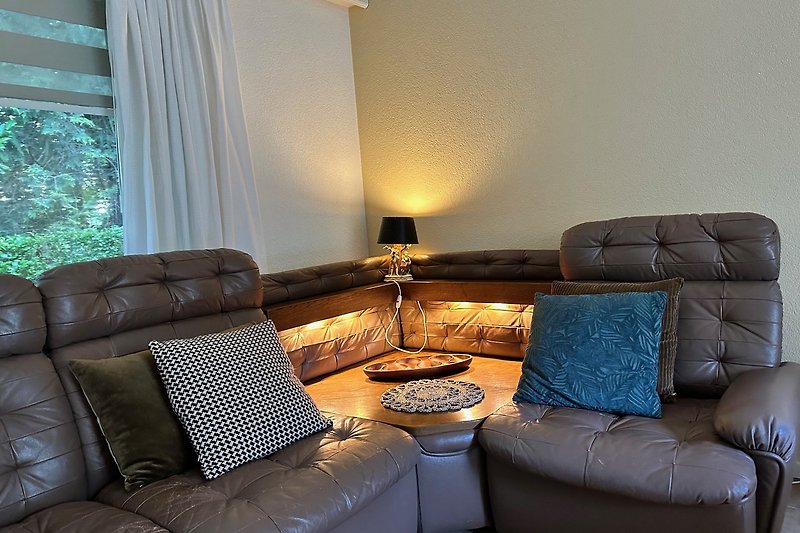 Comfortabele woonkamer met vintage hoekbank en sfeervolle verlichting.