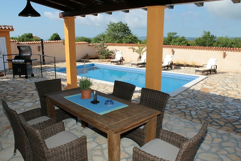 Ein sonniger Ort mit einem Pool, Liegestühlen und einer Terrasse - perfekt zum Entspannen im Urlaub.
