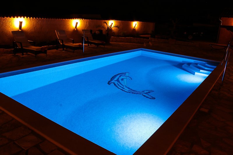 beleuchteter Pool bei Nacht