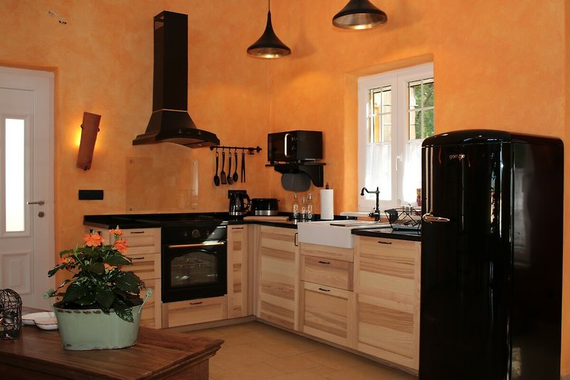 Eine moderne Küche mit schönen Holzmöbeln und einer großen Fensterfront.