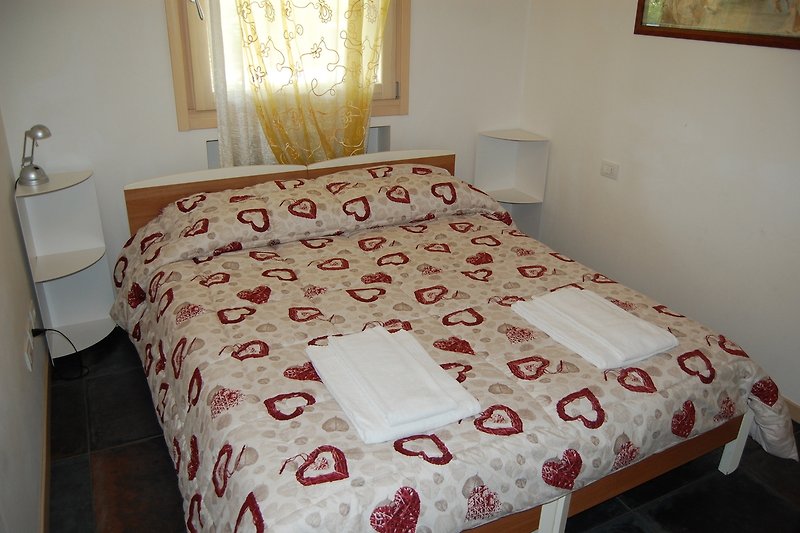 Gemütliches Schlafzimmer mit stilvollem Bett und schöner Inneneinrichtung.