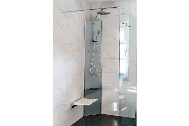 Modernes Badezimmer mit stilvoller Dusche, Glaswand und Sitz