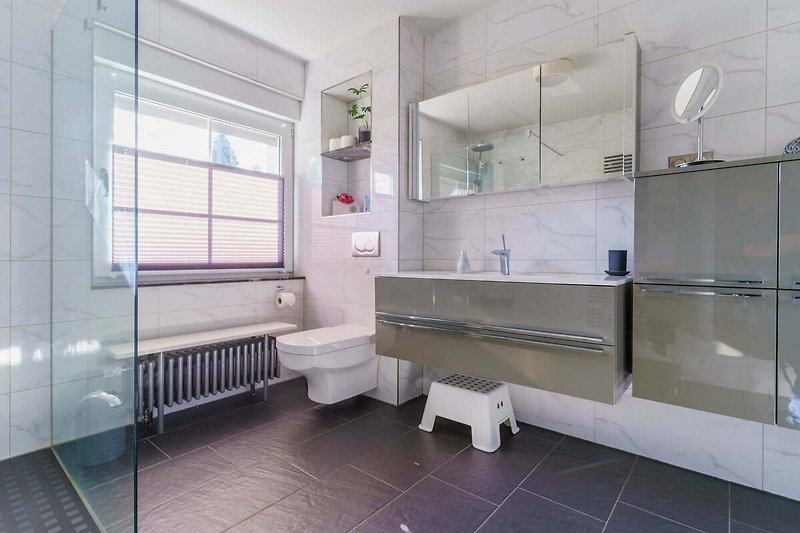 Modernes Badezimmer mit stilvoller Einrichtung und großem Fenster.