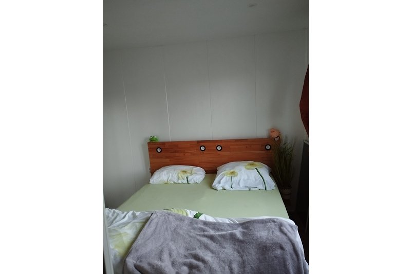 Gemütliches Schlafzimmer mit Holzbett und stilvoller Einrichtung.