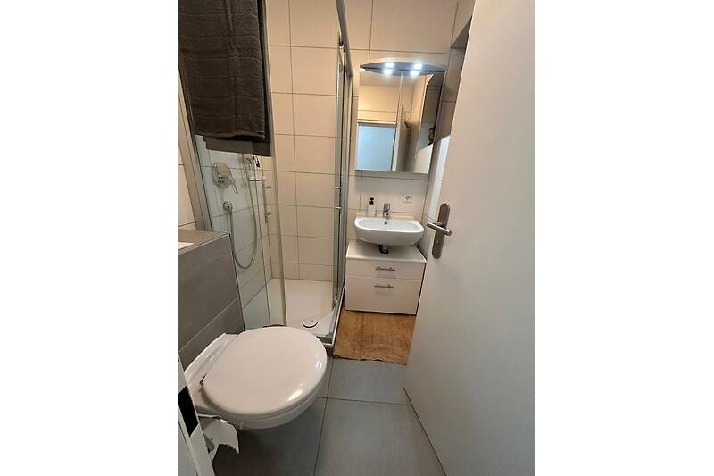 Stilvolles Badezimmer mit lila Akzenten und elegantem Design.