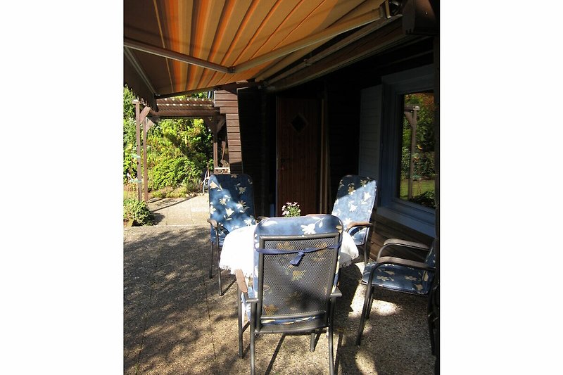 Terrasse und gemütlichem Sitzplatz und Sonnenschutz.
