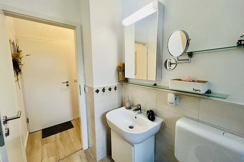 Badezimmer mit lila Dekoration, Spiegel und Waschbecken