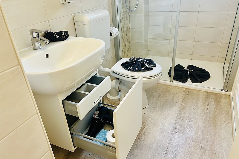Badezimmer mit stilvoller Einrichtung, Holzboden und Marmorwaschbecken.
