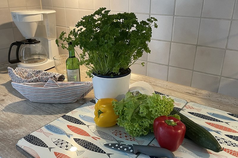 Schöne Tischdekoration mit Kräuter, Geschirr und Gemüse.