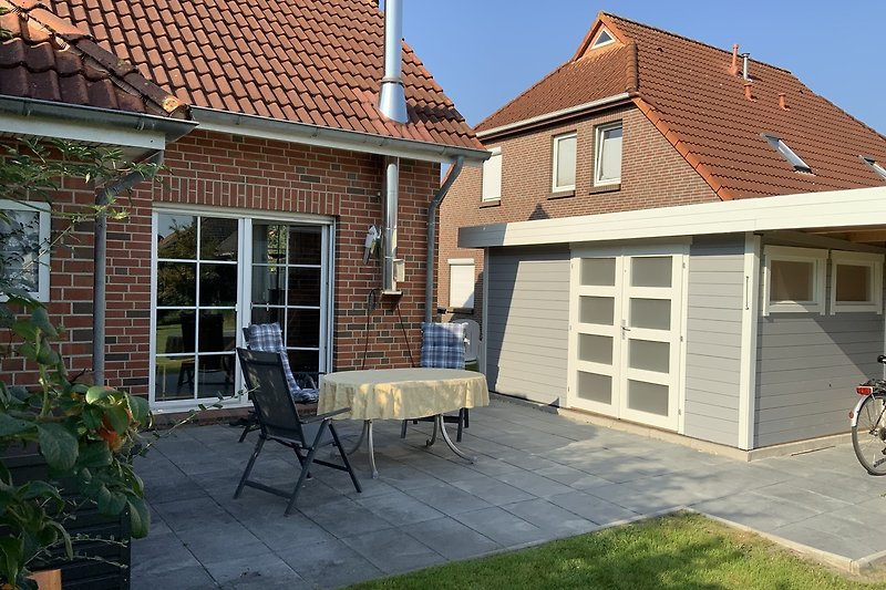 Neue Terrasse mit neuem Gartenhaus für Räder oder Kinderwagen