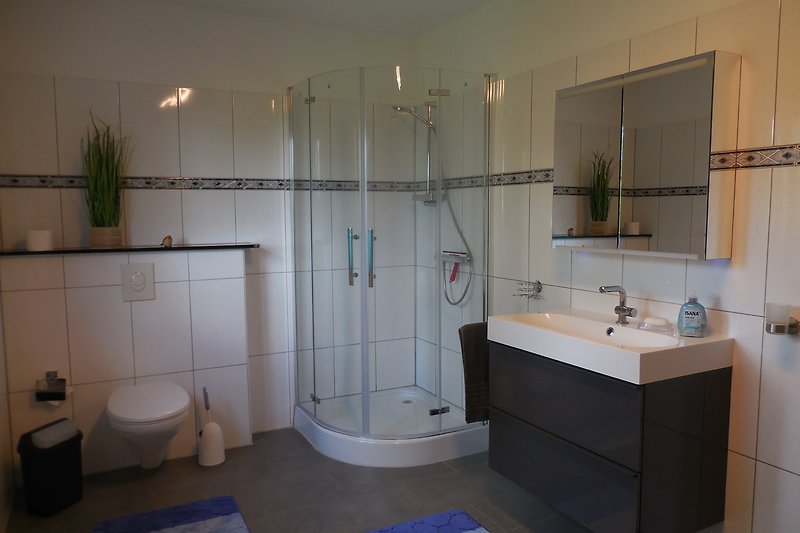 Ein stilvolles Badezimmer mit lila Akzenten und schönen Fliesen.