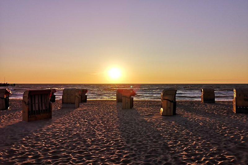 Gemütlicher Strand mit ruhigem Meer und atemberaubendem Sonnenuntergang.