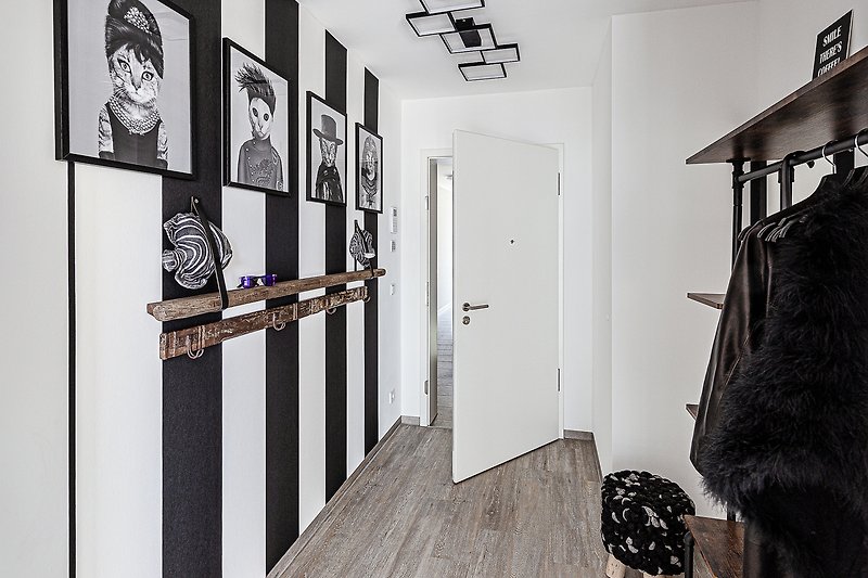Stilvolles monochromes Wohnzimmer mit Holzboden und Metallakzenten.