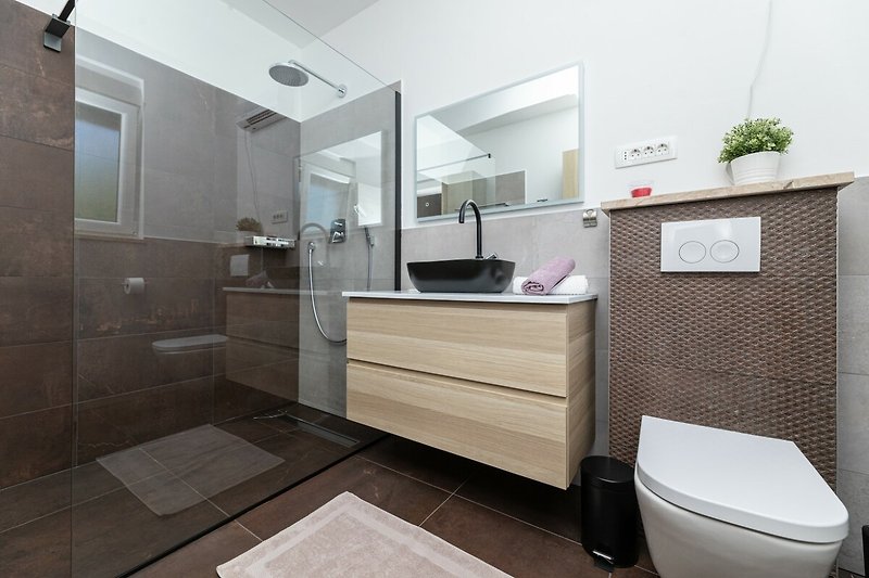 Badezimmer mit Spiegel, Waschbecken und Schrank. Modernes Design mit Holz und Metall.
