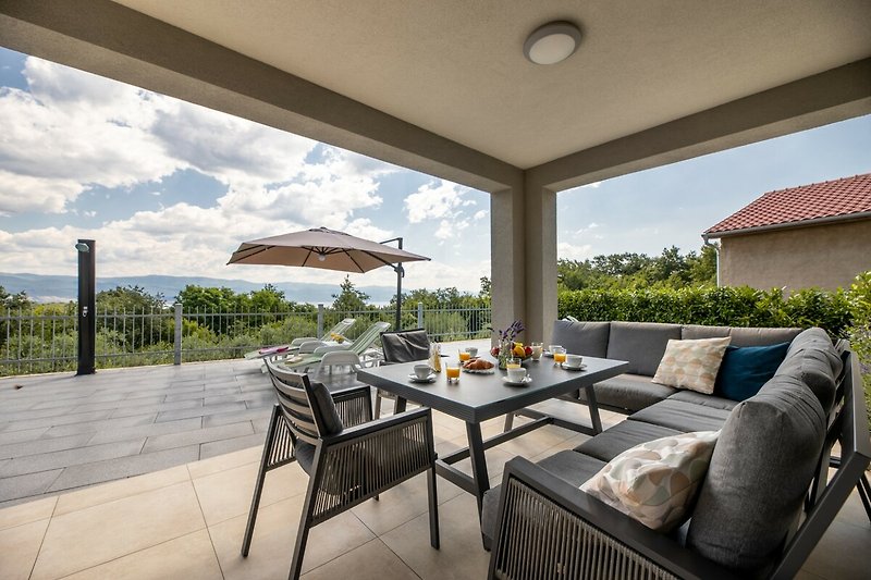 Schöne Aussicht auf die Terrasse mit Gartenmöbeln und grüner Umgebung.