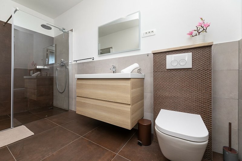 Udobna kupaonica s ljubičastim detaljima i modernim namještajem.