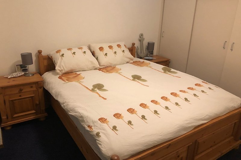 slaapkamer met comfortabel  opgemaakt bed en kastenwand