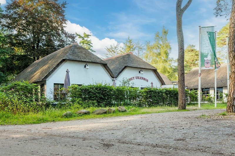 A charming countryside cottage surrounded by greenery and a well-maintained garden.