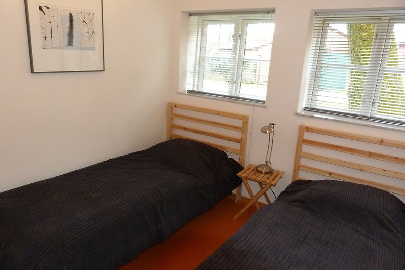 Schlafzimmer 2 mit Holzmöbeln und 2 Einzellbetten.