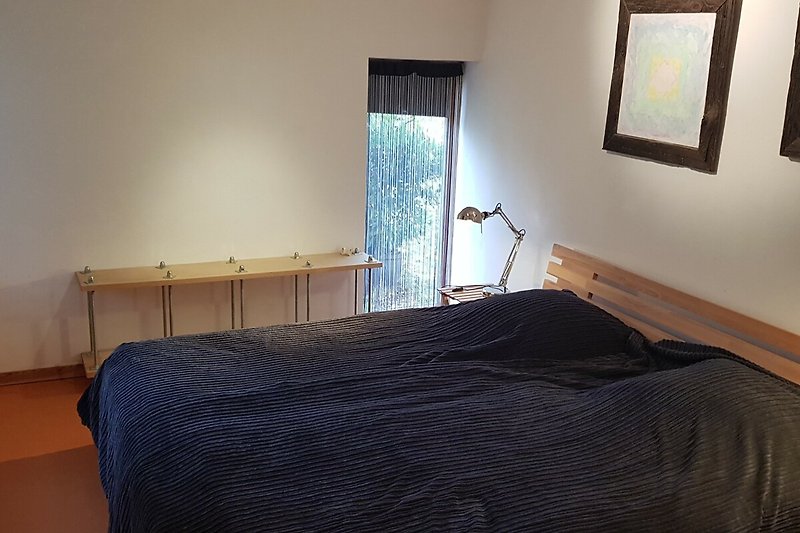 Schlafzimmer  1 mit Holzmöbeln und bequemem Doppelbett.