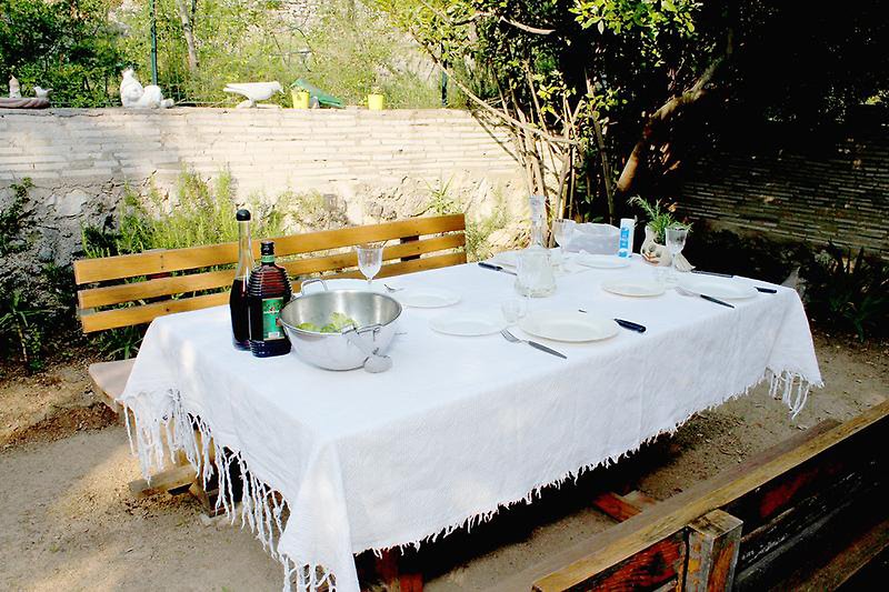 Tisch ist gedeckt, fehlen nur noch Gäste. Geschirr und Möbeln im Freien - perfekt für Veranstaltungen und Mahlzeiten.