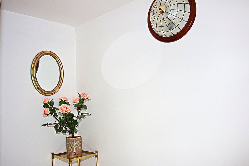 Ein stilvolles Zimmer mit Pflanzen, Blumen und einer eleganten Beleuchtung.