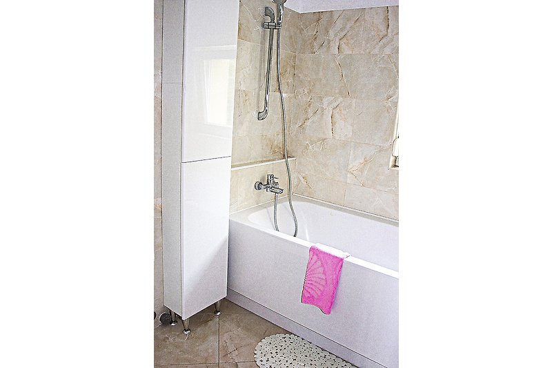 Eine moderne Dusche mit Glaswand und Metallarmatur.