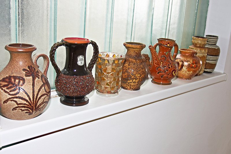 Einladendes Stillleben mit antiken Keramikgefäßen und Holzregal.