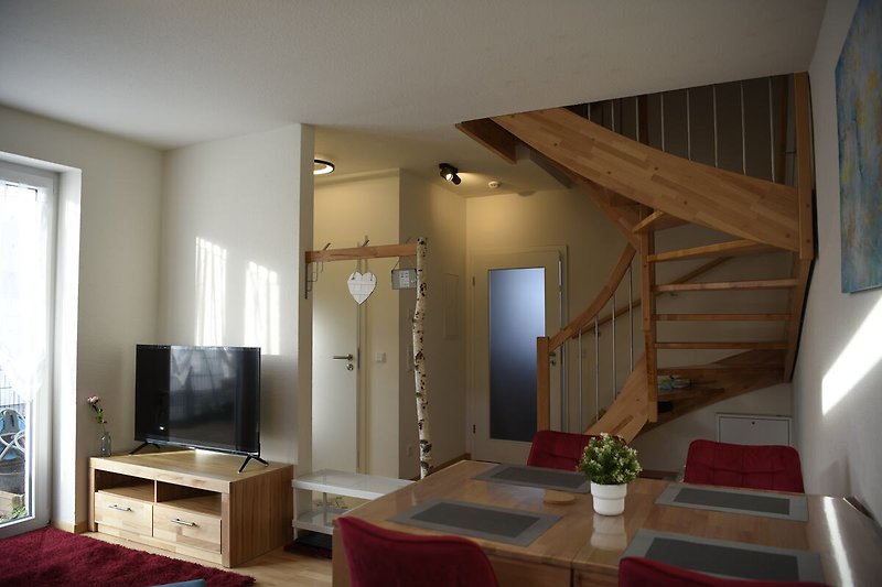 Gemütliches Wohnzimmer mit stilvollen Möbeln und Pflanzen mit Blick zur Küche, Buchen-Treppe