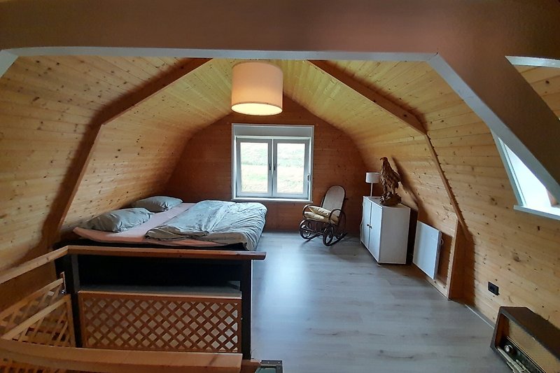 Slaapkamer met tweepersoonsbed. Met uitkijk op de zeedijk