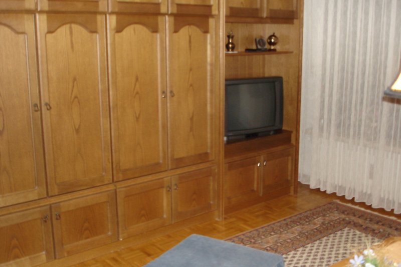 Gemütliches Wohnzimmer mit elegantem Holzmobiliar und stilvoller Beleuchtung.