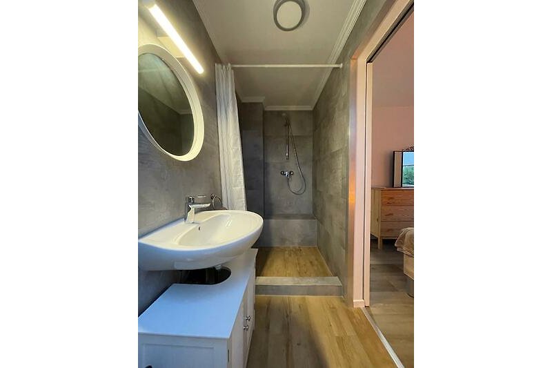 Ein stilvolles Badezimmer mit Spiegel, Waschbecken und Holzdetails.
