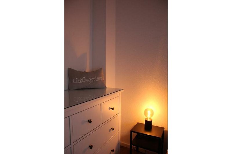 Schöne Holzmöbel und stilvolle Beleuchtung im Schlafzimmer