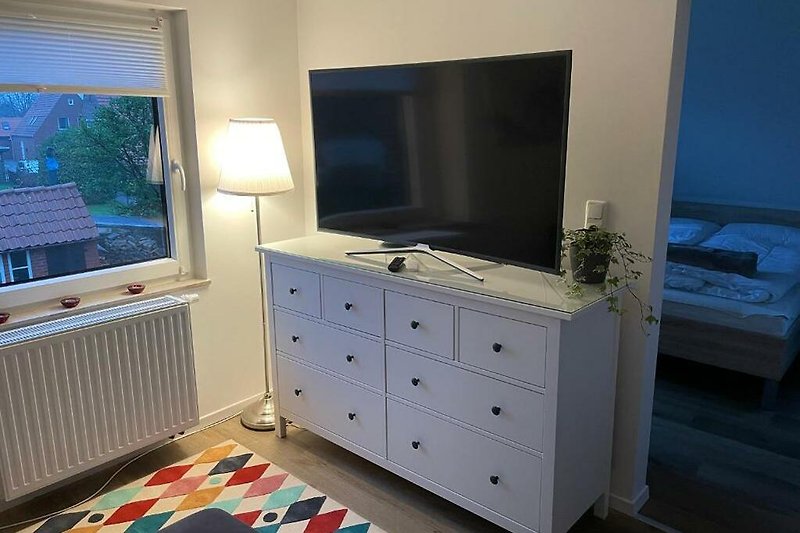 Gemütliches Wohnzimmer mit Holzmöbeln und Smart-TV
