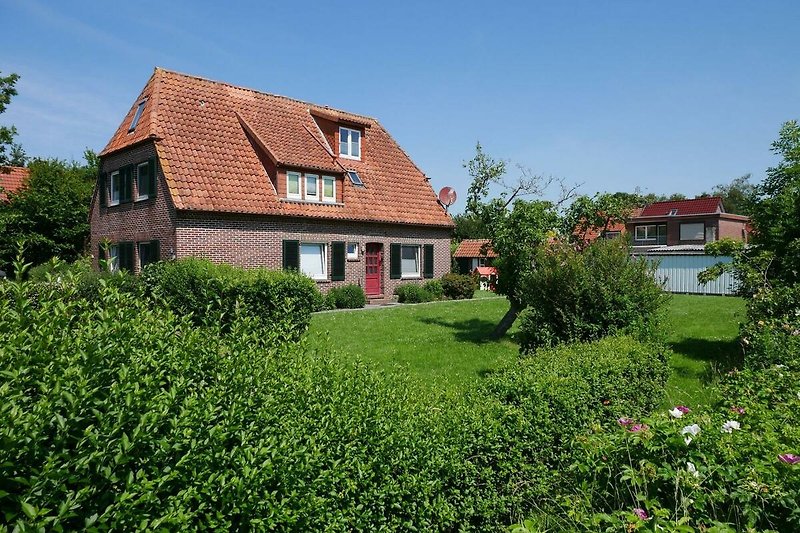Schönes Haus mit grünem Garten und malerischer Landschaft.