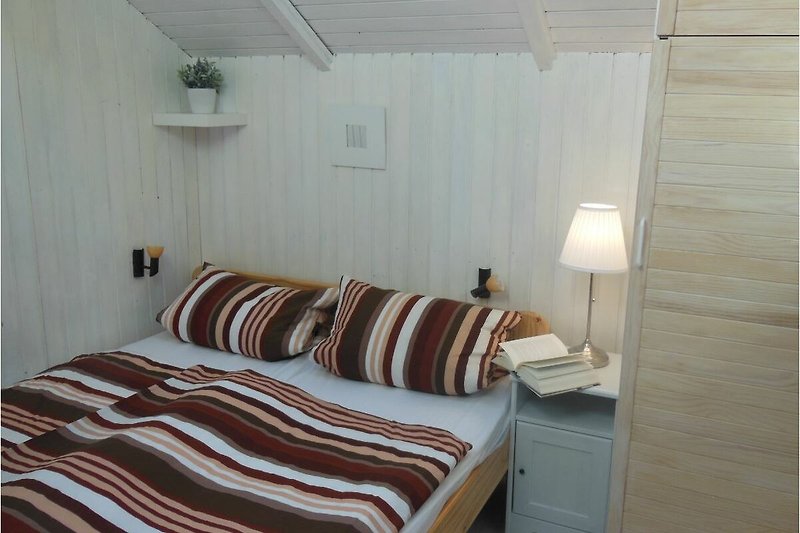 Ein komfortables Schlafzimmer mit stilvollem Holzbett und gemütlicher Beleuchtung.