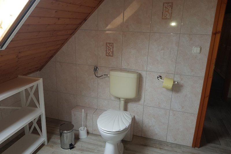 Ein modernes Badezimmer mit Toilette, Waschbecken und Fliesen.