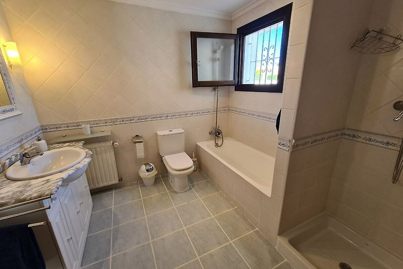 Nice bathroom with wooden furniture, sink, bath tub and shower