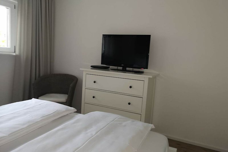 Gemütliches Schlafzimmer mit bequemem Bett und Magenta-TV Angebot