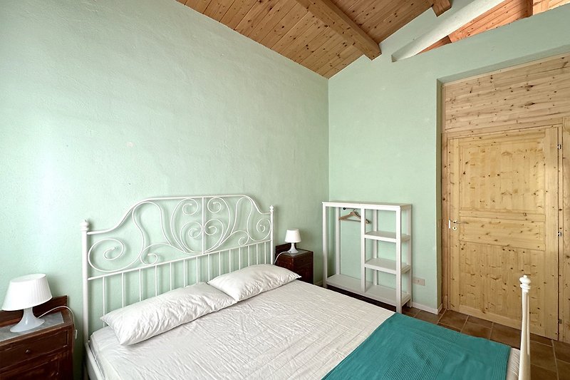 Una camera da letto accogliente con mobili in legno e una lampada a sospensione.