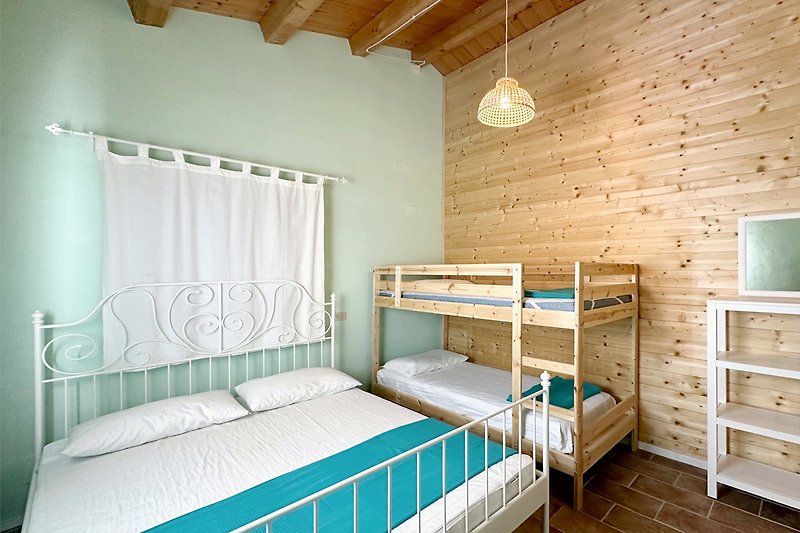 Una camera da letto accogliente con mobili in legno e una lampada a sospensione.