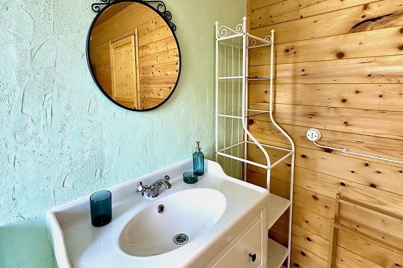 Un bagno moderno con lavabo, specchio e rubinetteria elegante.